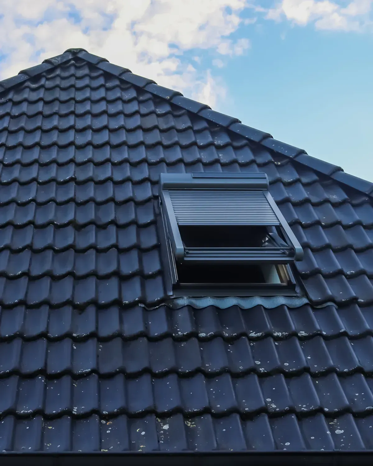 Vented skylight with blackout blind on dark charcoal tile roof — roofing La Quinta CA