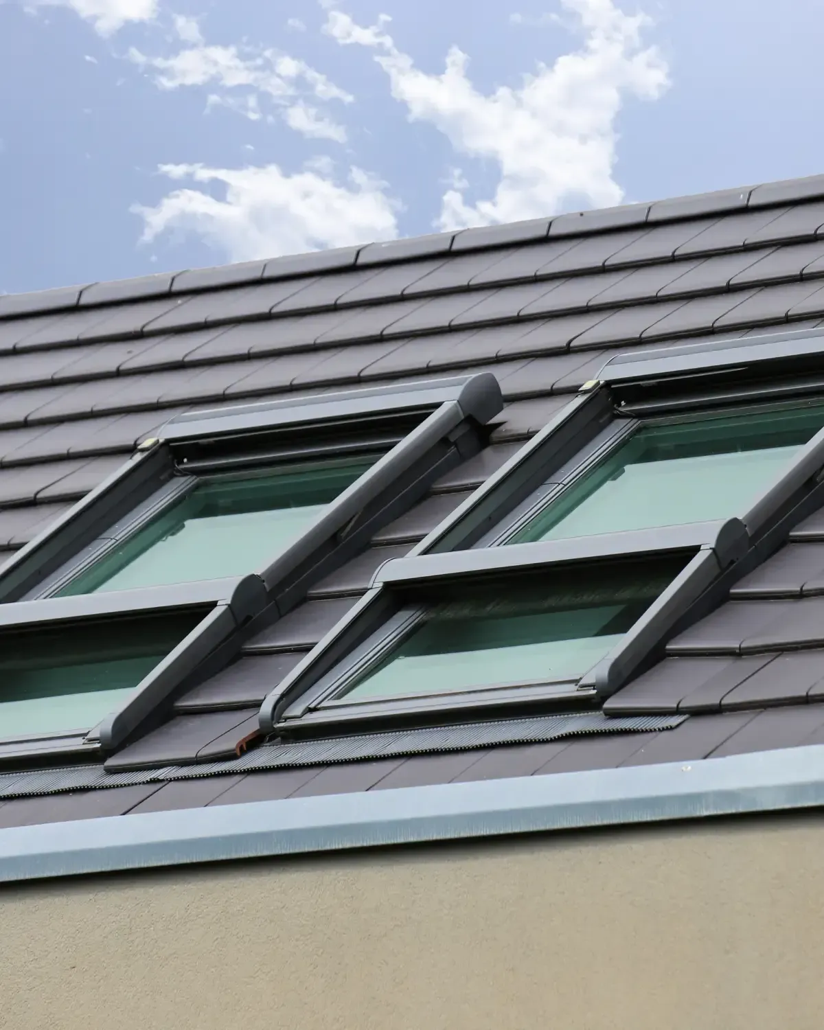 Four paired vented skylights installed on dark flat tile roof — roofing contractor Palm Springs
