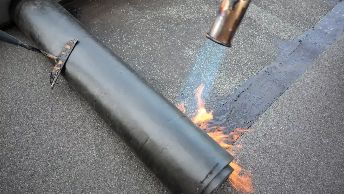 Torch flame heat-welding bituminous membrane on flat roof — what is the best roofing material for a flat roof