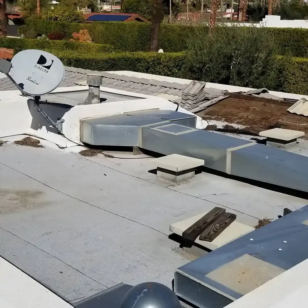 Flat roof inspection showing satellite dish and HVAC  units on Southern California commercial property by Dove Roofing