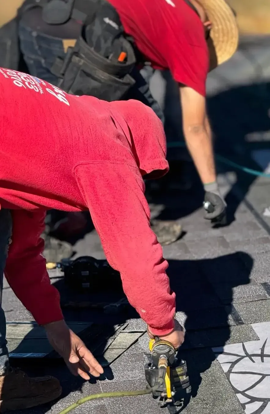 Roofing crew nailing dark asphalt shingles on residential roof — roofing contractor Palm Springs