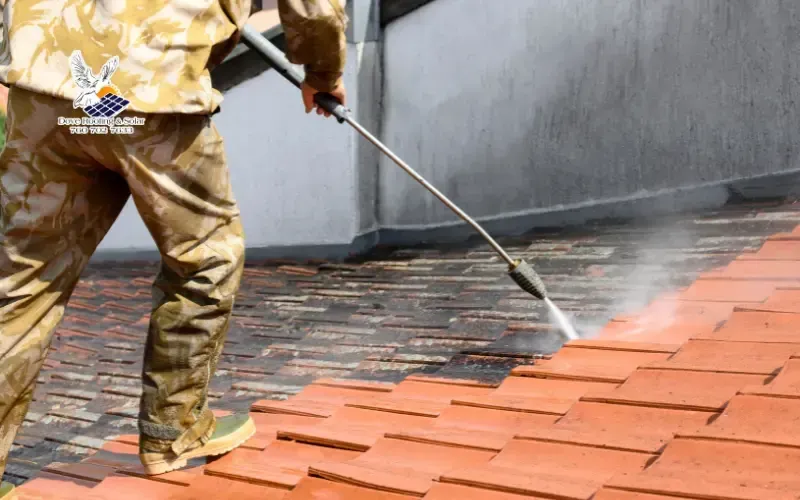 Roofing technician power washing a clay tile roof in Joshua Tree, CA