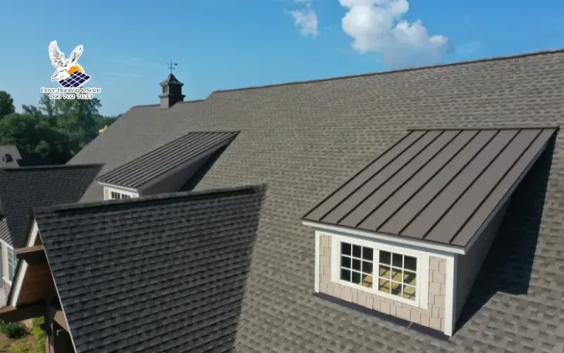 Aerial view of a shingle roof with a metal-clad dormer