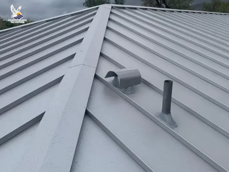 Standing seam metal roof installation surrounded by pine forest