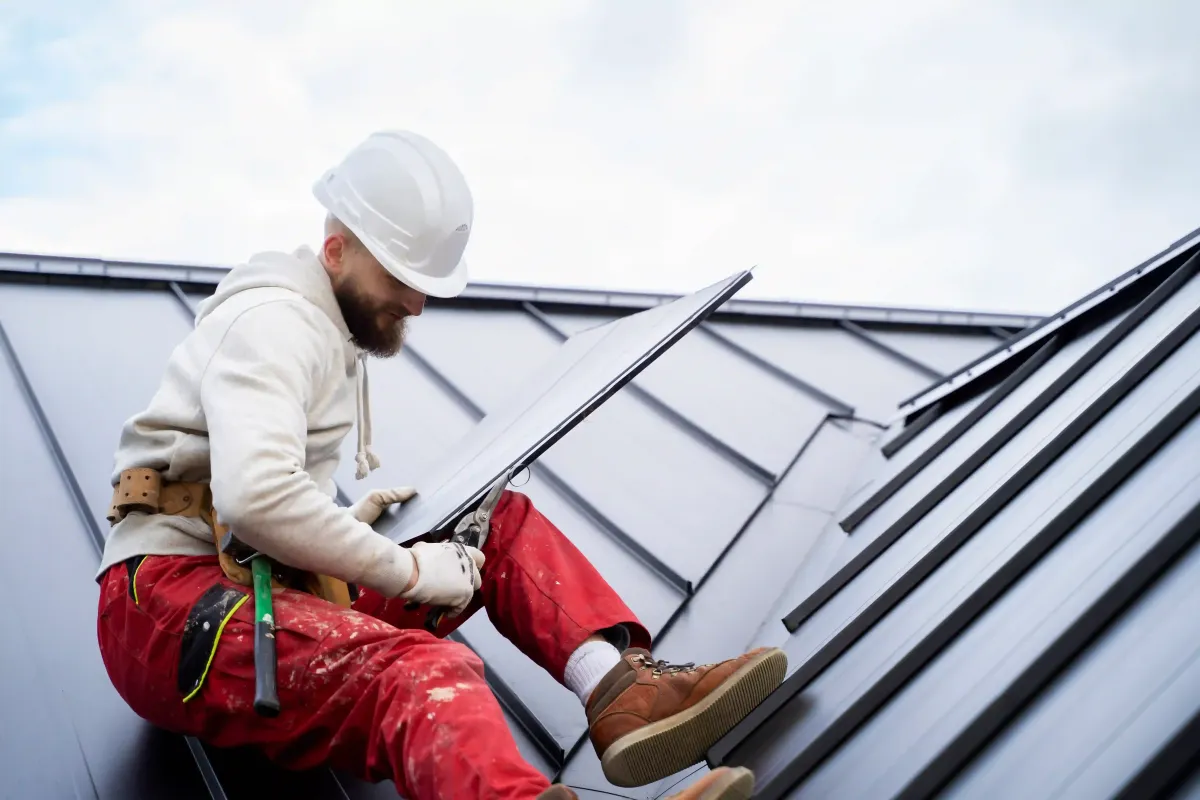 Roofing contractor inspecting a standing-seam metal roof during a professional roof inspection