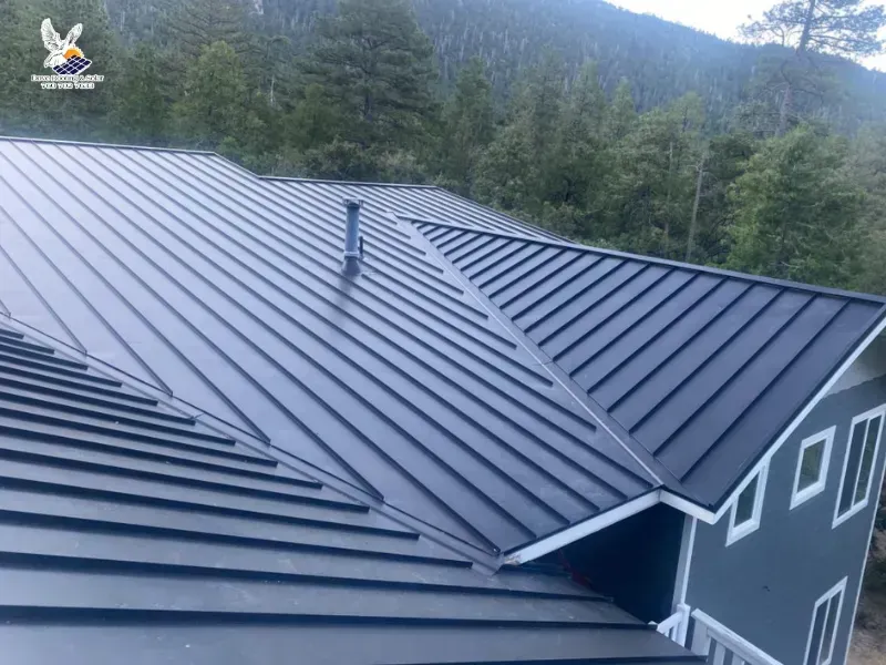 Standing-seam metal roof on a home surrounded by forest.