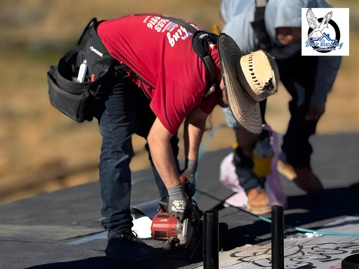 Two roofers installing material on a shingle roof