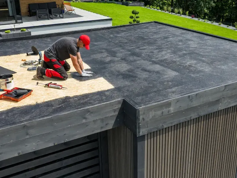 Roofing contractors installing flat roof membrane and materials on a rooftop