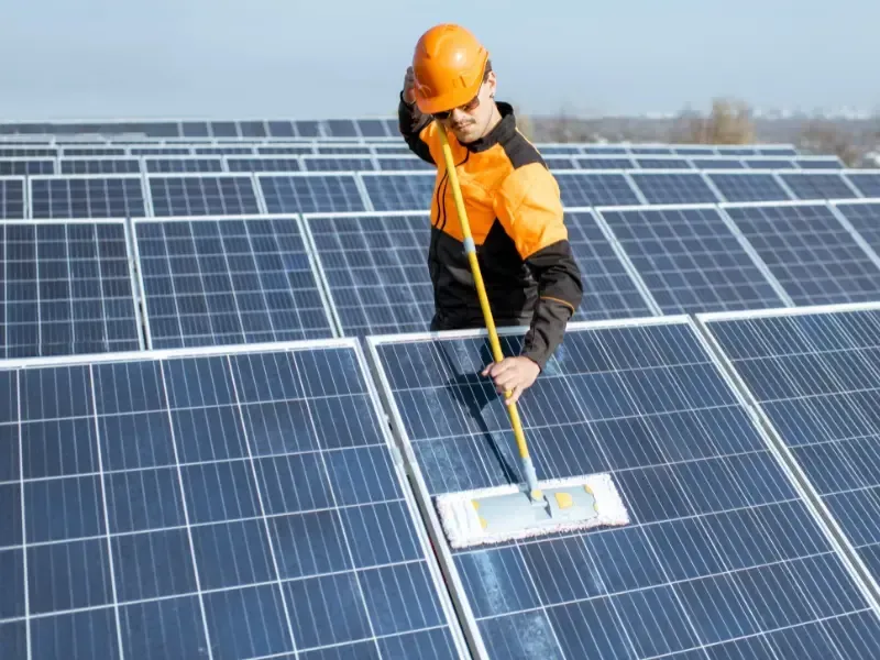 Technician cleaning solar panels — Dove Roofing roof and solar maintenance services in Hidden River, CA.