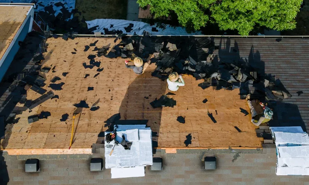 Aerial of crew tearing off old shingles and re-decking a home — roofing contractor near me Palm Springs