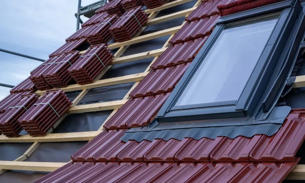 Black vented skylight on terracotta tile roof under blue sky — roofing services Palm Springs CA
