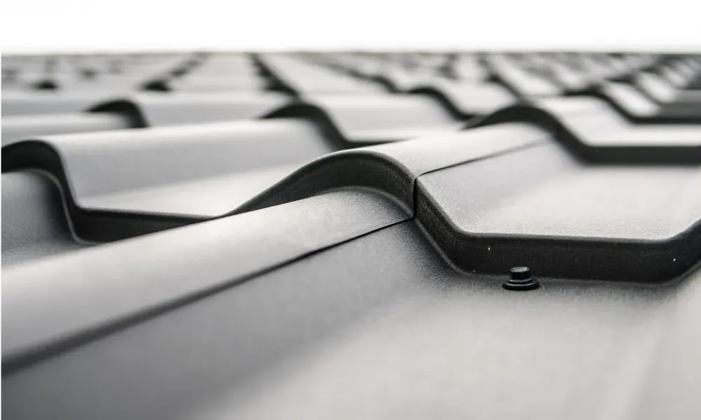 Close-up of pneumatic nail gun fastening new asphalt shingles — how do you install roof shingles