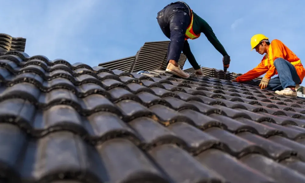 Hand lifting damaged shingle revealing gap at eave — what are signs of roof damage after a storm