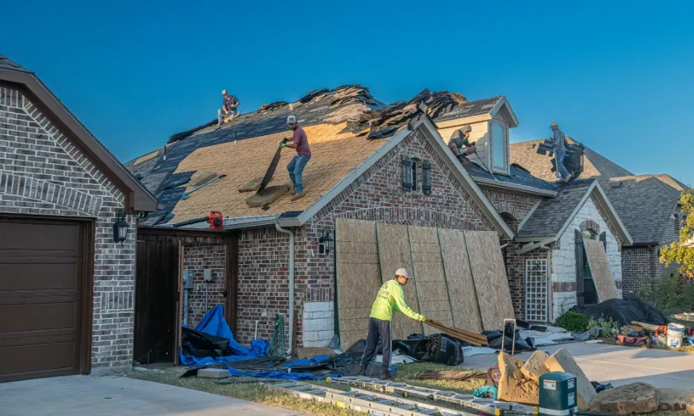Aerial of crew tearing off old shingles and re-decking a home — roofing contractor near me Palm Springs