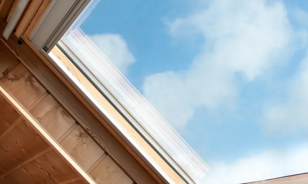 Black vented skylight on terracotta tile roof under blue sky — roofing services Palm Springs CA