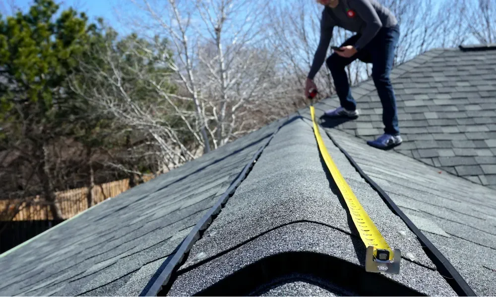 Hand lifting damaged shingle revealing gap at eave — what are signs of roof damage after a storm