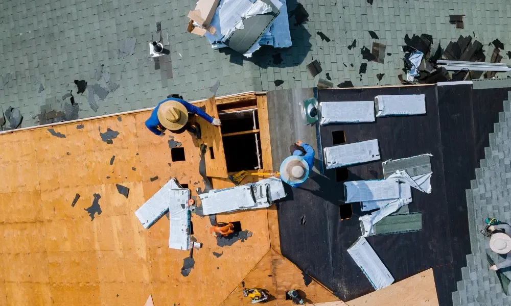 Aerial of crew tearing off old shingles and re-decking a home — roofing contractor near me Palm Springs
