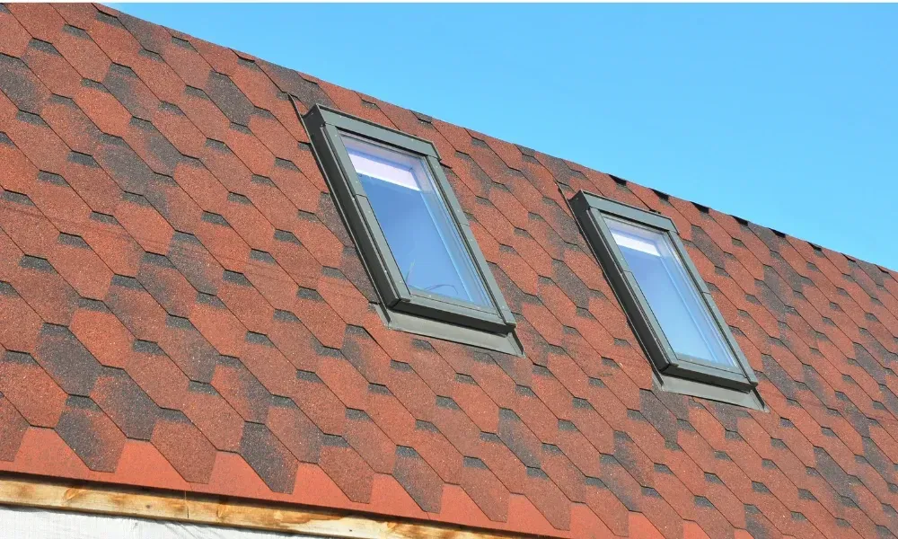 Black vented skylight on terracotta tile roof under blue sky — roofing services Palm Springs CA