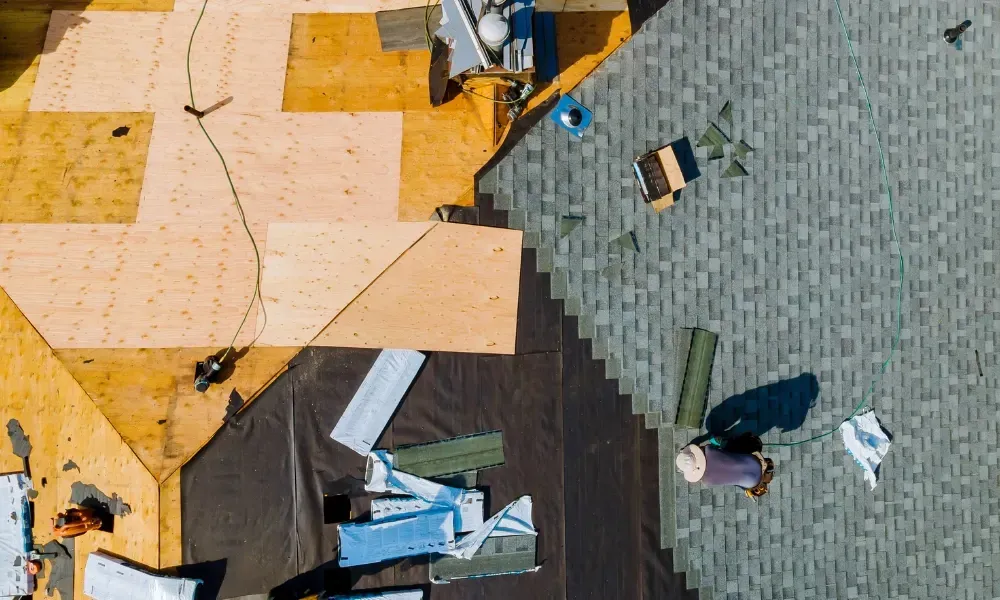 Aerial of crew tearing off old shingles and re-decking a home — roofing contractor near me Palm Springs