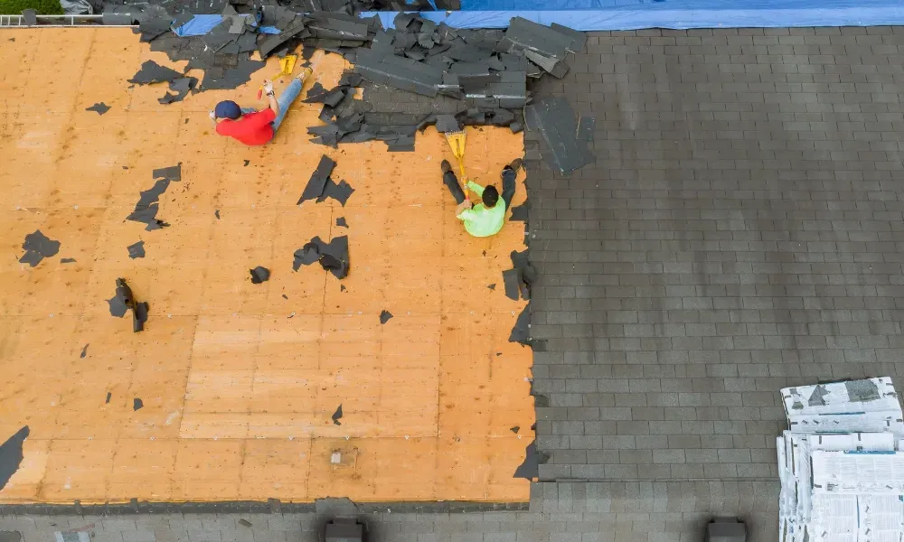 Aerial of crew tearing off old shingles and re-decking a home — roofing contractor near me Palm Springs