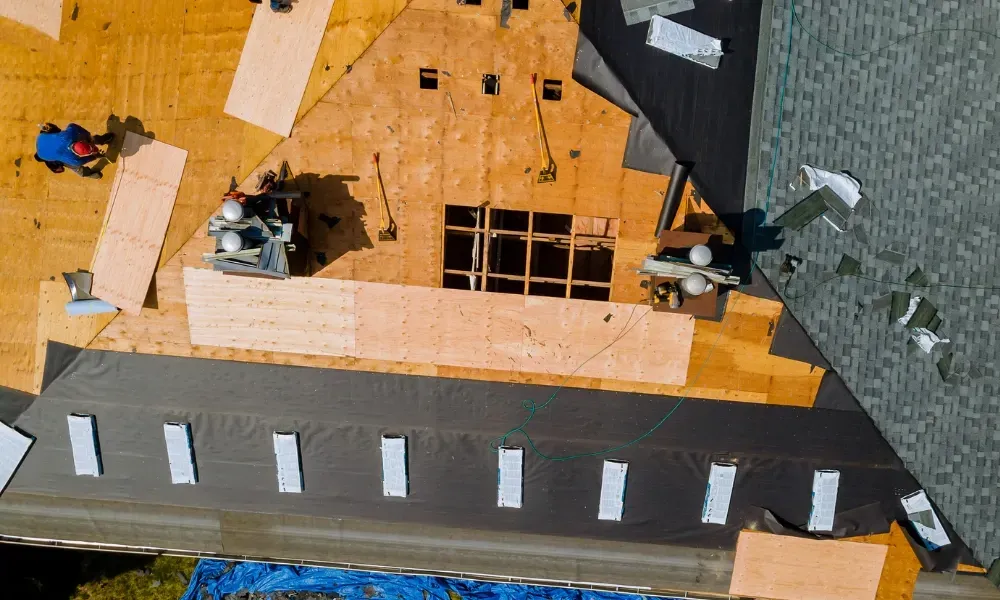 Aerial of crew tearing off old shingles and re-decking a home — roofing contractor near me Palm Springs