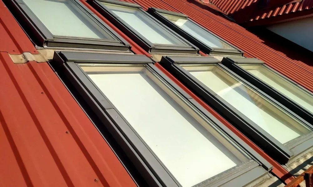 Worker power washing red clay tile roof to remove moss and debris — how to remove moss from roof