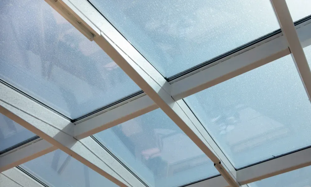 Black vented skylight on terracotta tile roof under blue sky — roofing services Palm Springs CA