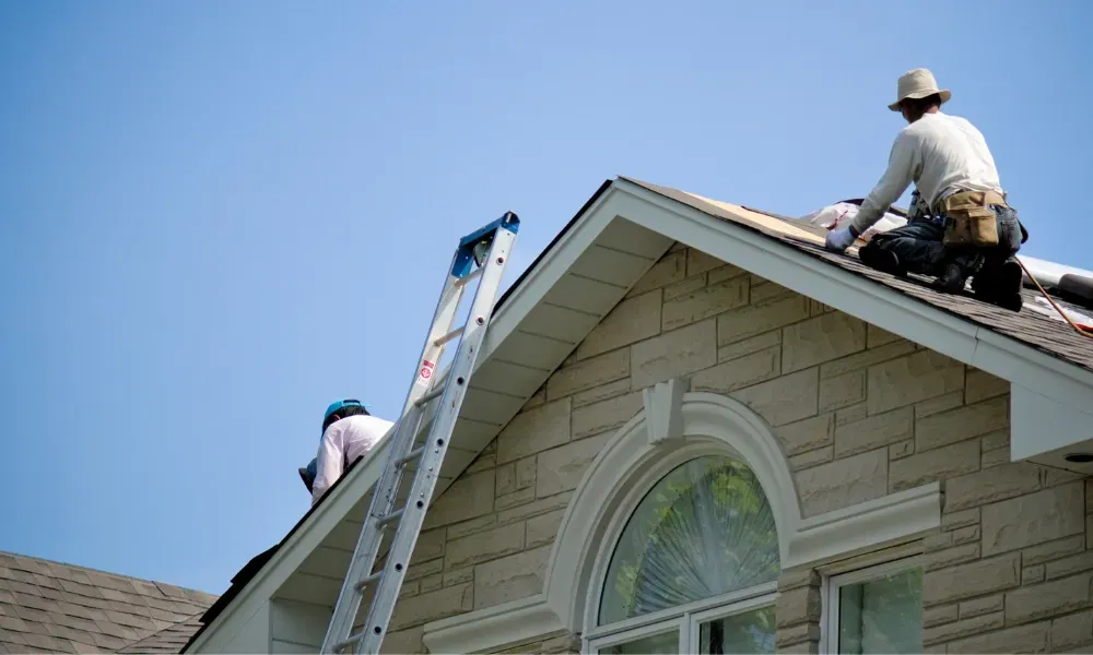 Hand lifting damaged shingle revealing gap at eave — what are signs of roof damage after a storm