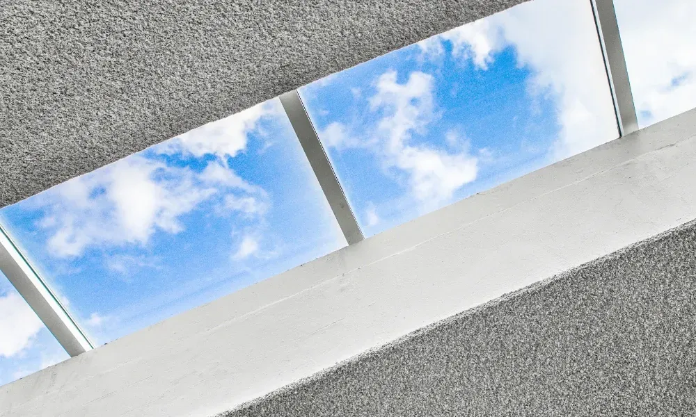 Black vented skylight on terracotta tile roof under blue sky — roofing services Palm Springs CA