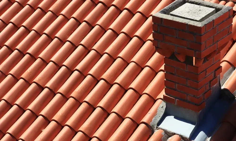 Close-up of pneumatic nail gun fastening new asphalt shingles — how do you install roof shingles