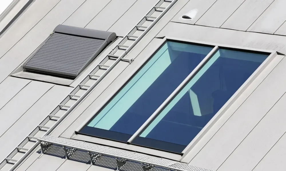 Black vented skylight on terracotta tile roof under blue sky — roofing services Palm Springs CA