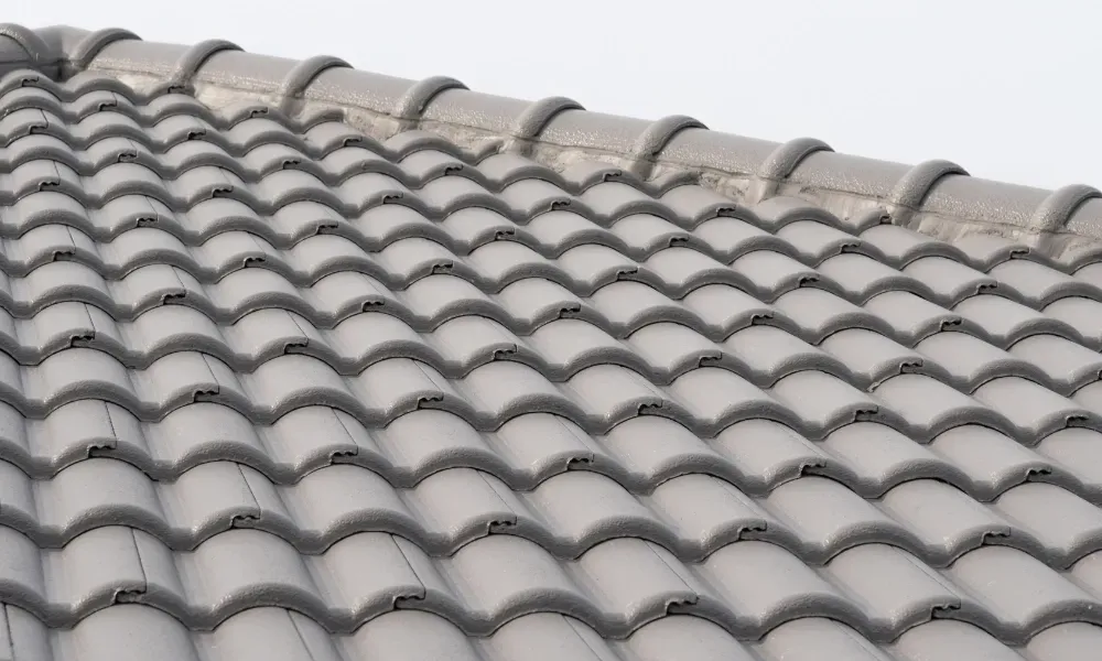 Close-up of pneumatic nail gun fastening new asphalt shingles — how do you install roof shingles