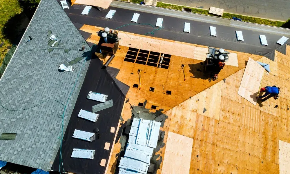 Aerial of crew tearing off old shingles and re-decking a home — roofing contractor near me Palm Springs