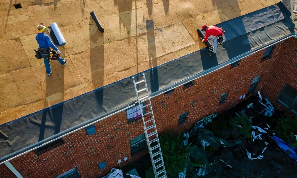 Aerial of crew tearing off old shingles and re-decking a home — roofing contractor near me Palm Springs