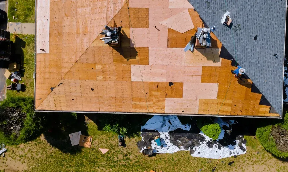 Aerial of crew tearing off old shingles and re-decking a home — roofing contractor near me Palm Springs