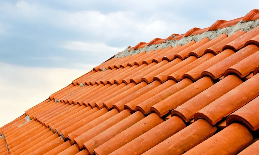 Close-up of pneumatic nail gun fastening new asphalt shingles — how do you install roof shingles