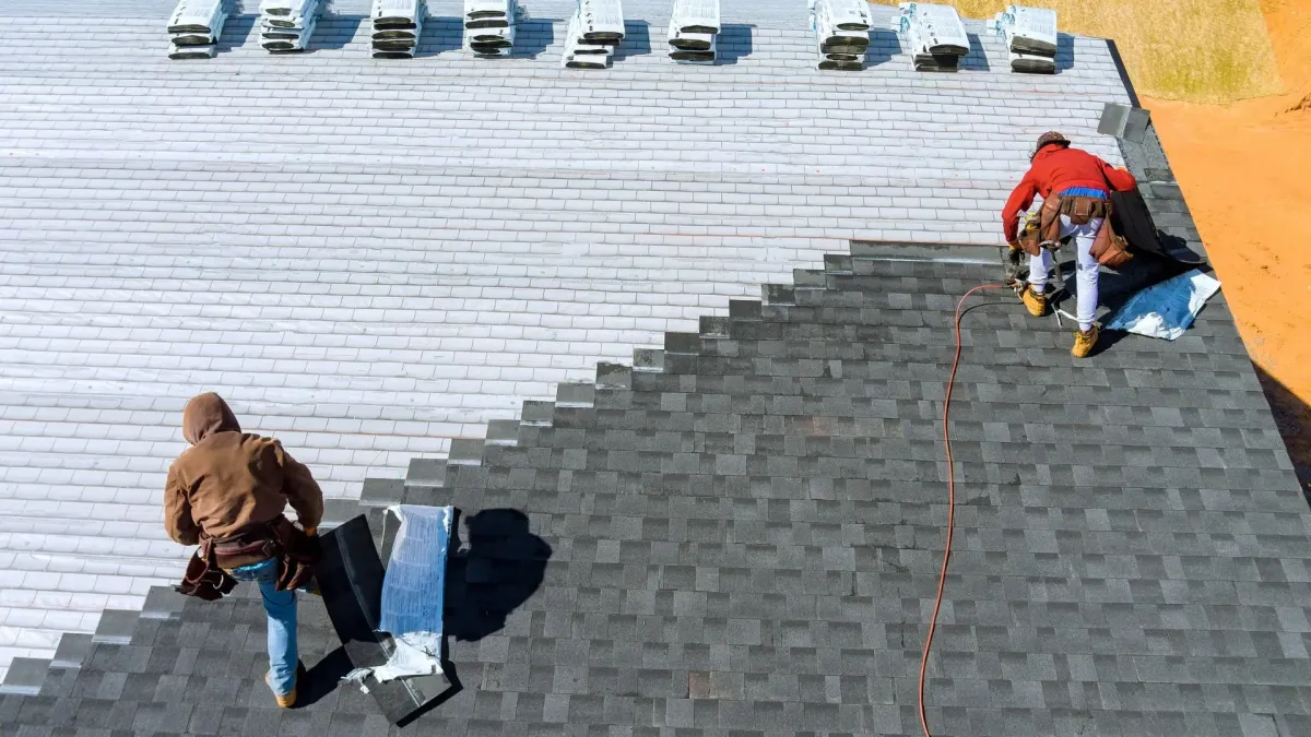 Exposed roof deck after tear-off showing damaged sheathing sections being replaced before new underlayment goes down