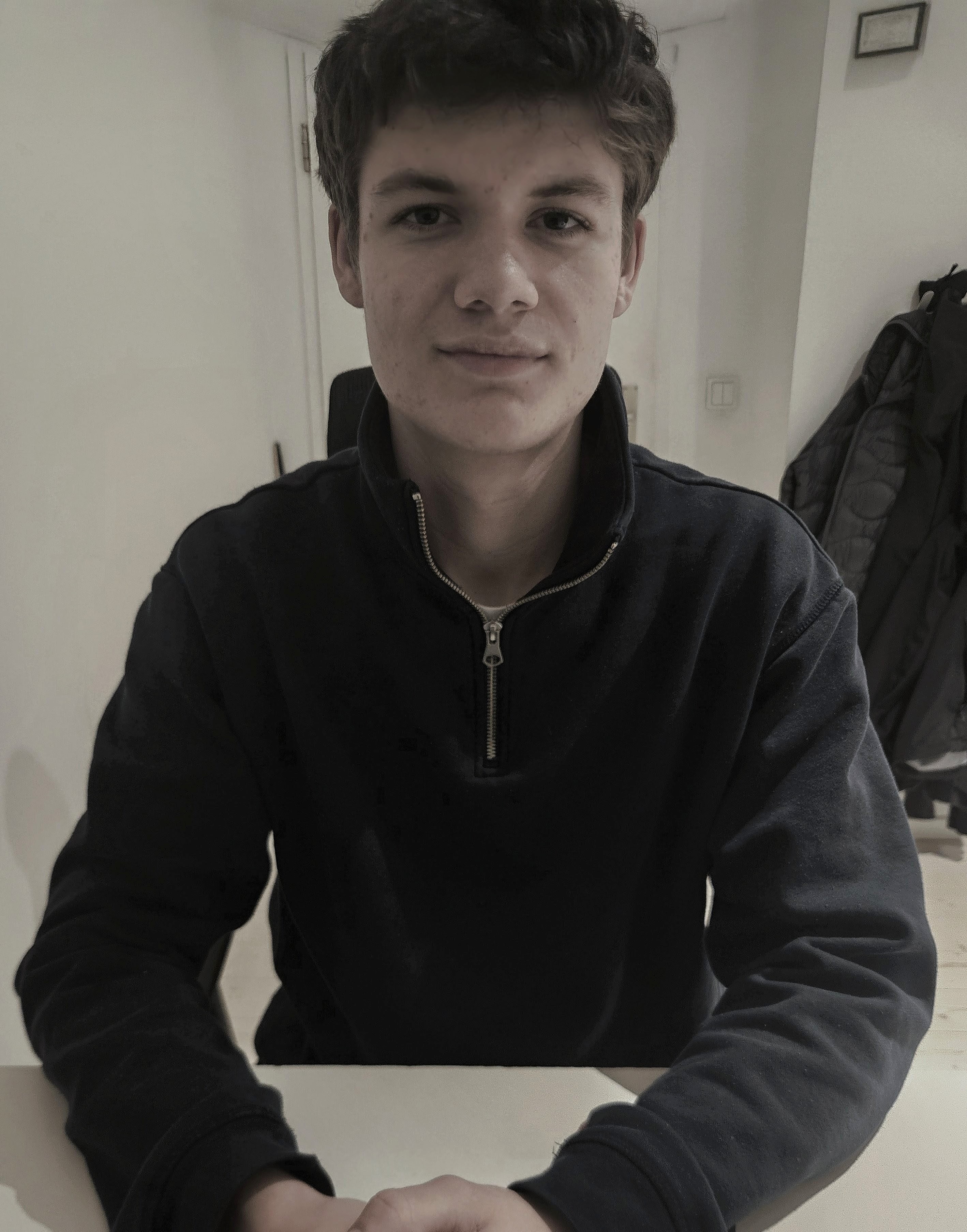 Porträt eines sympathischen, jungen Gründers mit Brille, lächelt freundlich, modernes Büro im Hintergrund, Teammitglieder arbeiten an Laptops, helle Atmosphäre, Fokus auf persönliche Beratung und digitale Kompetenz, Frankfurt