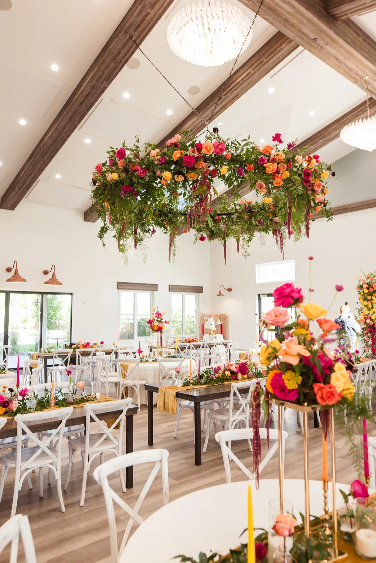 Suspended floral chandelier installation in pink, coral, and green designed by Andrea Robertson of Flamingo Friday Floral Co.