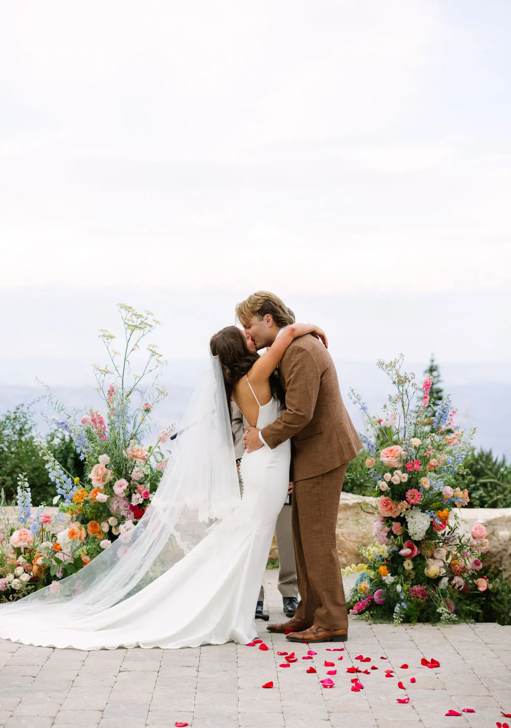 Bride and groom embracing beside a mountain ceremony meadow at Snowbasin