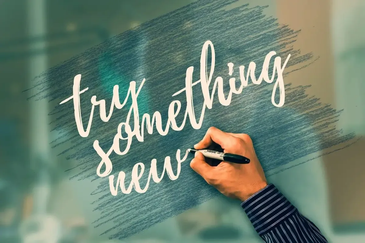 Handwriting the phrase ‘try something new,’ encouraging potential clients to explore hypnosis and breathwork for healing.