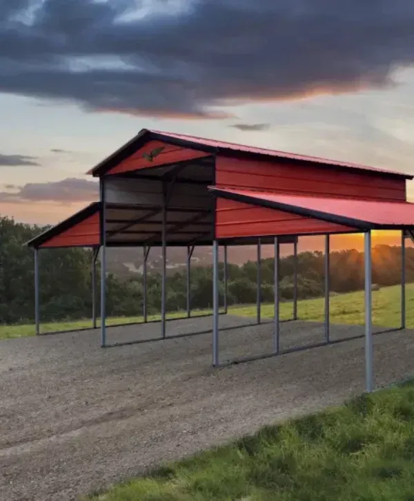 Large red metal RV carport with a scenic sunset view in the background