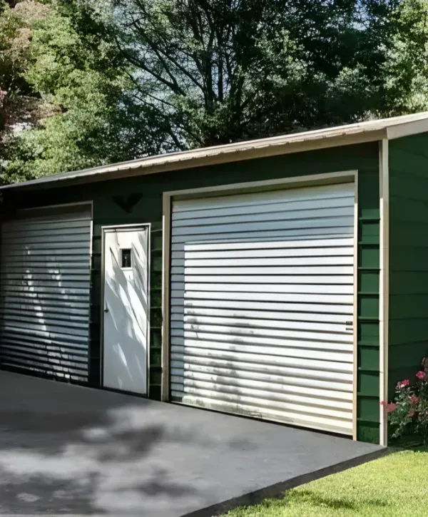 Green metal garage with white roll-up doors and side entry door