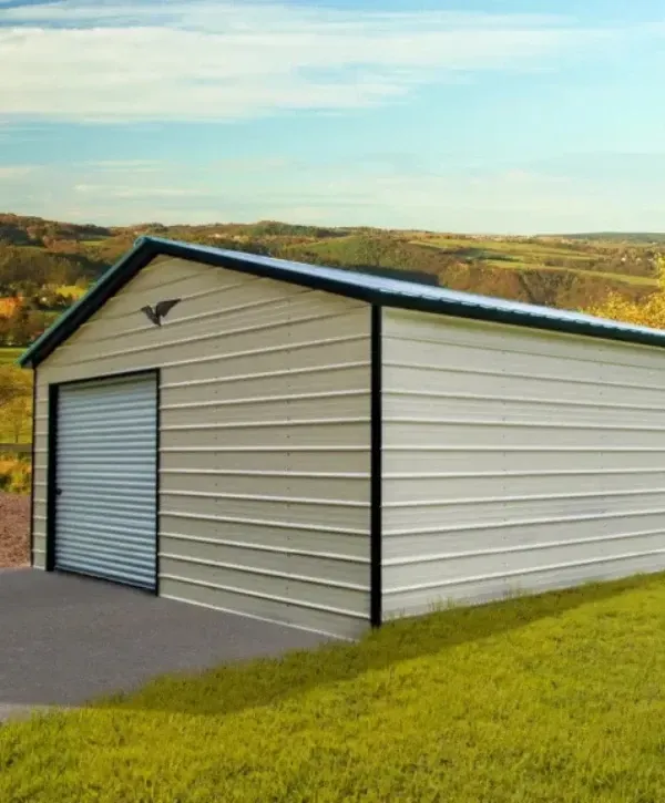 Exterior view of a metal storage building with a roll-up garage door in a rural area..