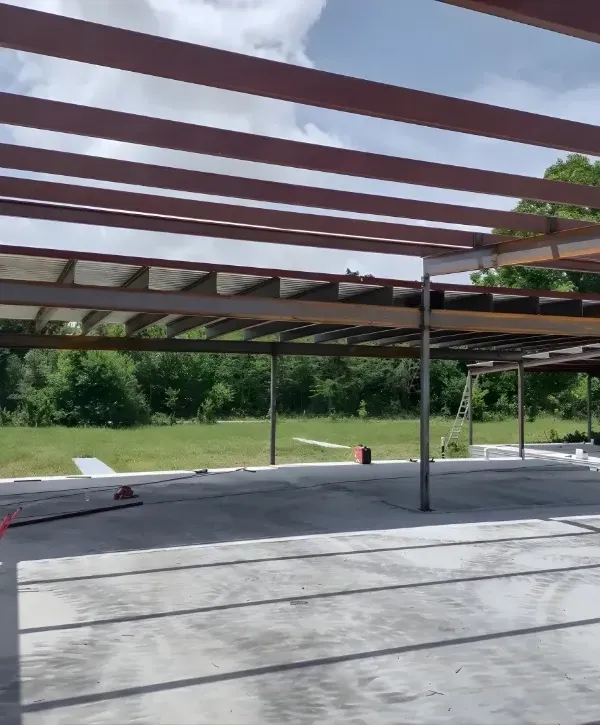 Steel roof frame construction of a metal building on a concrete foundation