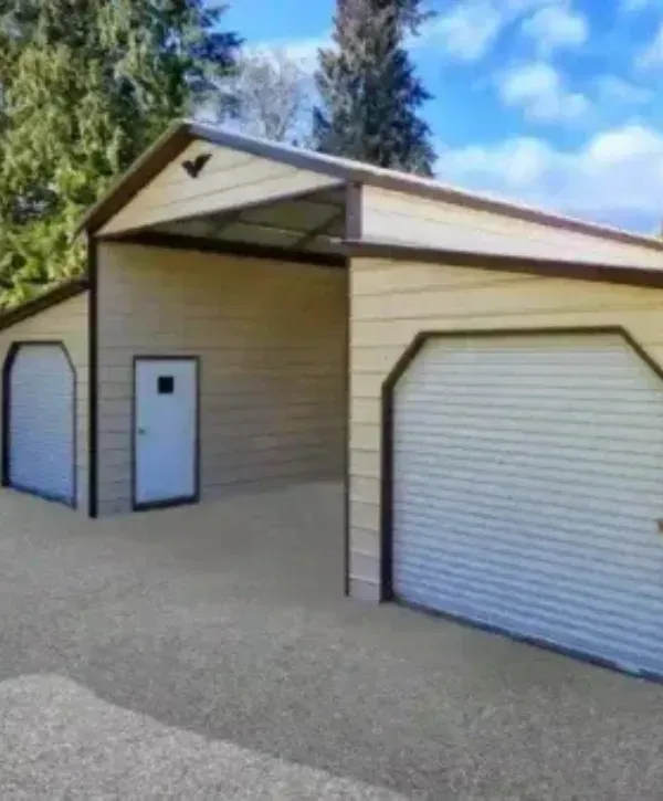 Large metal building featuring two roll-up garage doors and a central entry door.