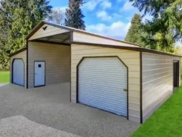 Large metal building with dual roll-up garage doors and beige siding, surrounded by trees.