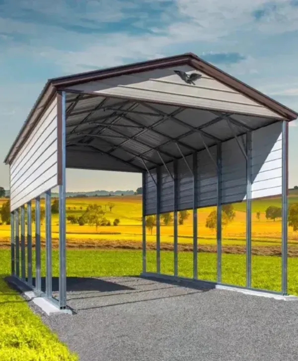 Open-sided metal carport structure installed on a gravel base in a rural field