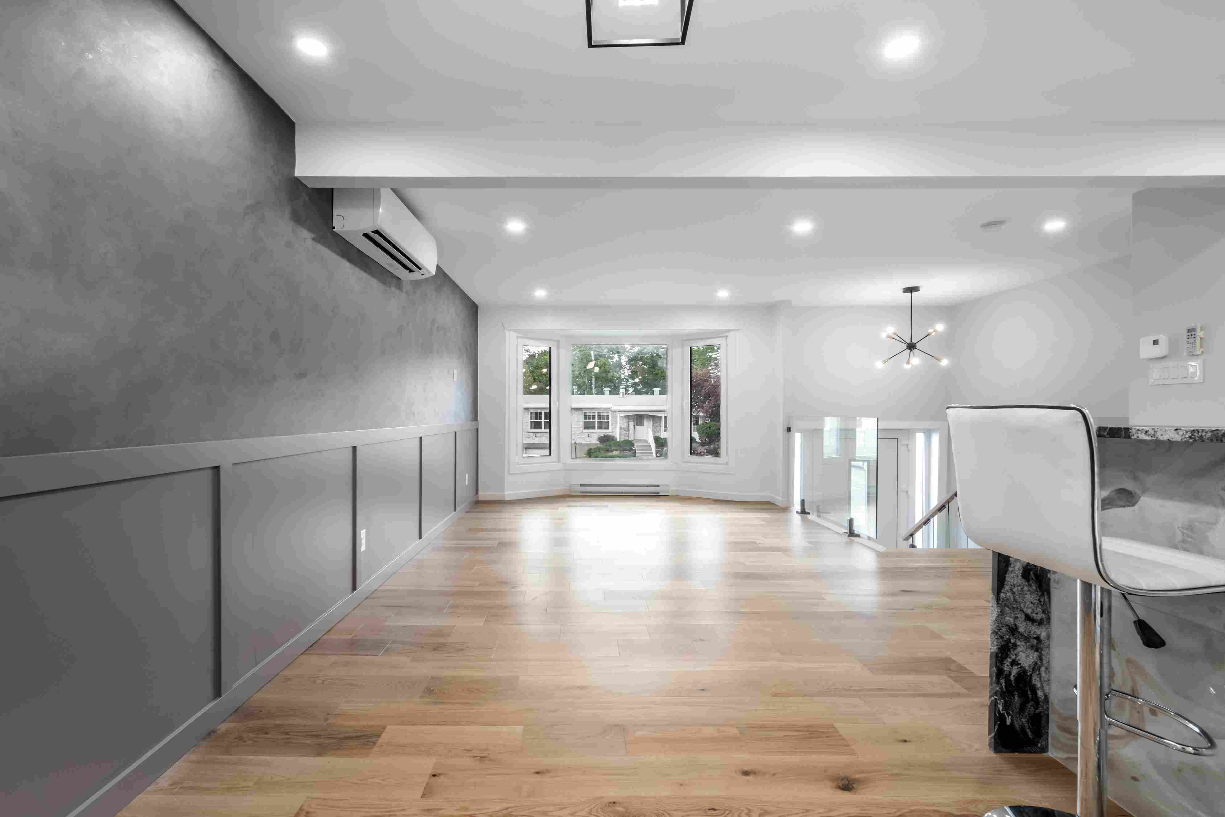 Luxury basement renovation in Edmonton with open space, large window, modern lighting and hardwood flooring