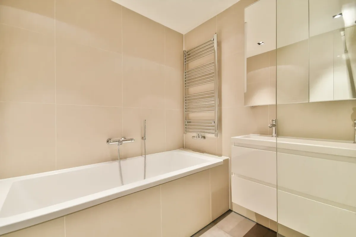 Modern bathroom renovation in Edmonton with bathtub, wall vanity, mirror cabinet and tiled walls